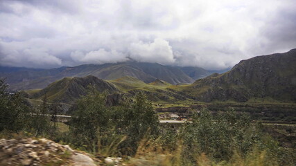 Mountain summer slopes of the Elbrus region, covered with forests, with glaciers and rivers. Elbrus region, Kabardino-Balkarian Republic, Russia.