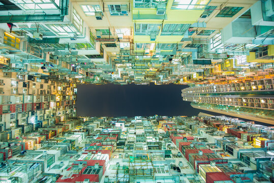 Low Angle View Of Residential Building In An Old Community With Building Lights On At Night In Quarry Bay, Hong Kong. 