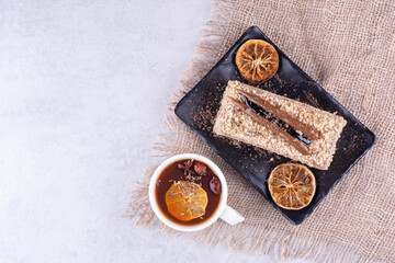 Plate of homemade cake with fruit tea on burlap