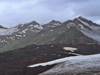 Mountain slopes of the Elbrus region with snow, glaciers and clouds. Elbrus region,...