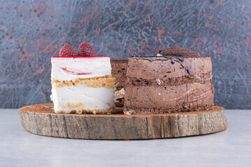 Variety of sweet cakes on wooden piece