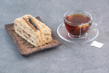 A piece of cake with cup of aroma coffee on gray background
