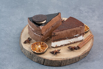 Two sweet delicious piece of cakes with star anise on wooden board
