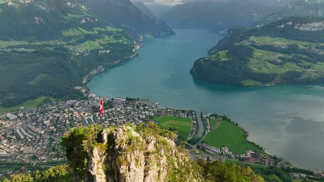 Swiss flag on a rock above beautiful Lucerne lake, panoramic aerial view of Luzern lake in Swiss Alps, amazing Swiss landscape 