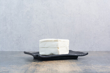 Organic white cheese on black plate