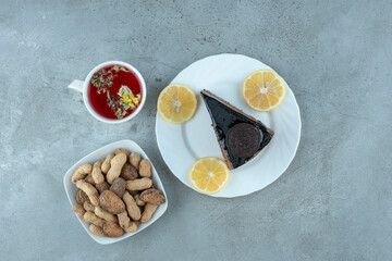Slice of chocolate cake with tea and peanuts