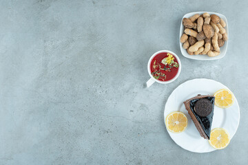 Slice of chocolate cake with tea and peanuts