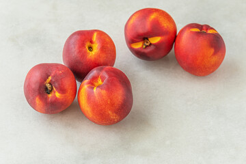 ripe sweet nectarines on a white marble surface