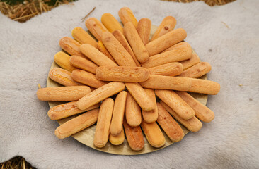 A plate full with sponge fingers biscuits used during an outdoor wedding ceremony.