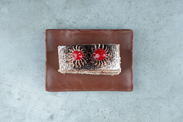 Slice of tasty cake on brown plate