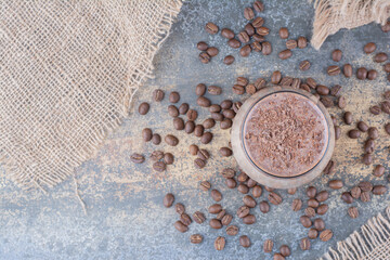 Fototapeta na wymiar A cup of delicious coffee with coffee beans on wooden board