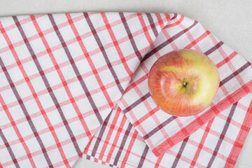 Fresh red apple on striped tablecloth