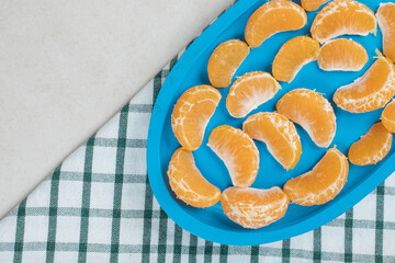 Juicy tangerine segments on blue plate