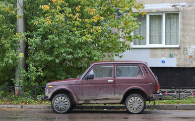 Old Soviet red dirty short-wheelbase Jeep, Iskrovsky Prospekt, St. Petersburg, Russia, September...