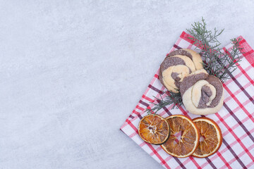 Cookies with dried orange on tablecloth and pine branch
