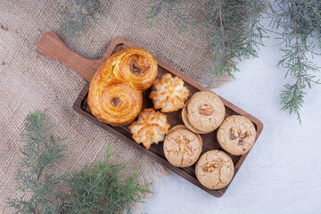Variety of delicious cookies on wooden board
