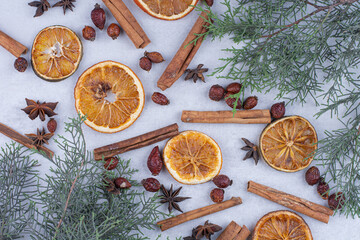 Cinnamon sticks, rosehips and dried orange slices on surface