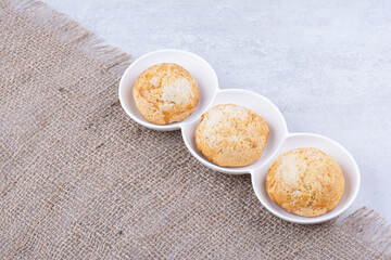 Yummy cookies in white bowls with burlap