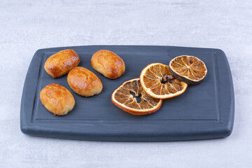 Homemade pastries with dried orange on dark plate