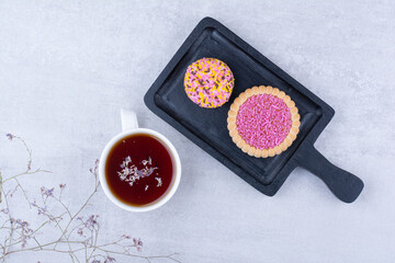 Cookies decorated with sprinklers and cup of tea