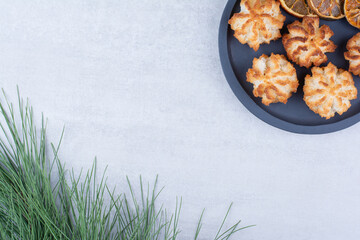 Coconut macaroons on dark board with orange slices