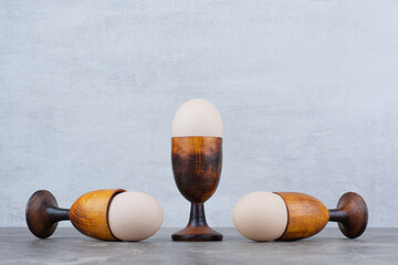 Chicken eggs in egg cups on marble background