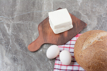 Fresh chicken eggs with bread on tablecloth