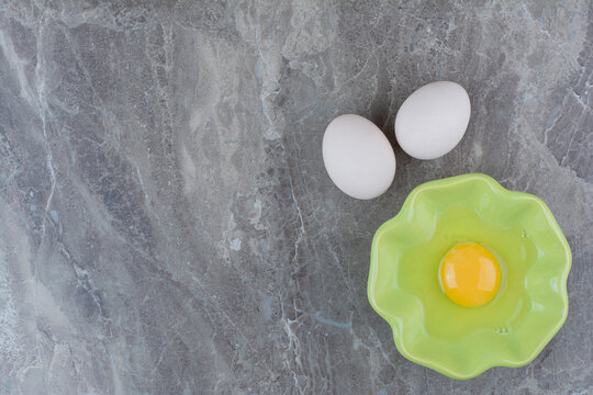 A Green Plate Of Raw Egg And Chicken Eggs