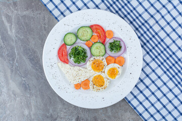 Tasty boiled eggs with spices and vegetables on tablecloth