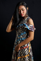 Beautiful young asian woman wearing batik isolated on black background. Batik Day.