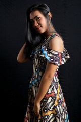 smiling young Asian woman wearing batik clothes isolated on black background. Batik Day.