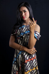 Beautiful young asian woman wearing batik isolated on black background. Batik Day.