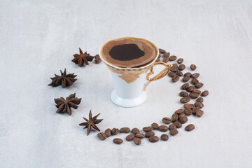Cup of coffee with coffee beans and cloves