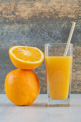 Orange fresh juice with slices of orange on marble background