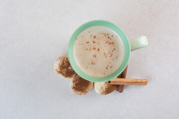 A cup of hot aroma coffee with cinnamon sticks on white background