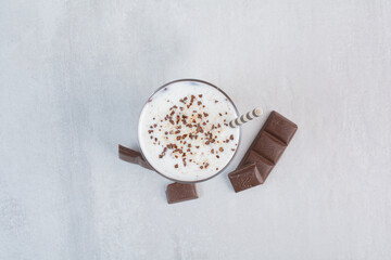 Glass of milk with straw and chocolate bar