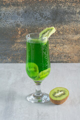 Delicious lemonade with slices of kiwi on marble background