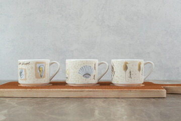 Three cups of coffee on wooden board