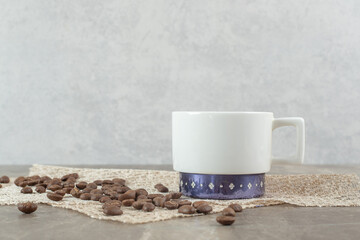 Coffee cup and coffee beans on marble table