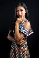 Beautiful young asian woman wearing batik isolated on black background. Batik Day.