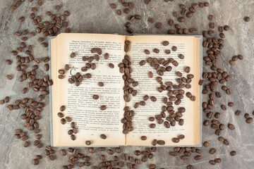 Bunch of coffee beans scattered on book