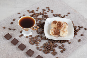 Cup of espresso with chocolate and cookies on marble background