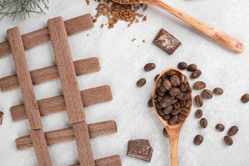 Coffee beans, ground coffee, biscuits and chocolate on marble surface