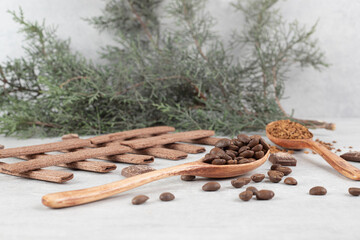 Coffee beans, ground coffee, biscuits and chocolate on marble surface