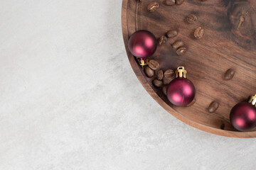 Coffee beans and Christmas balls on wooden plate