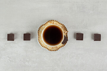 Cup of espresso with chocolate pieces on marble background