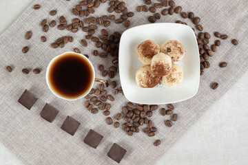 Cup of espresso with chocolate and cookies on marble background