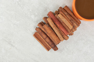 Cup of coffee with cinnamon stick on marble surface