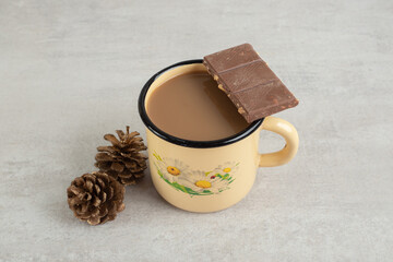 Cup of coffee with pinecones and chocolate bar