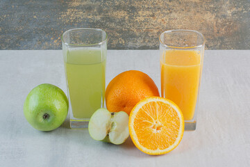 A green and orange drinks on marble background